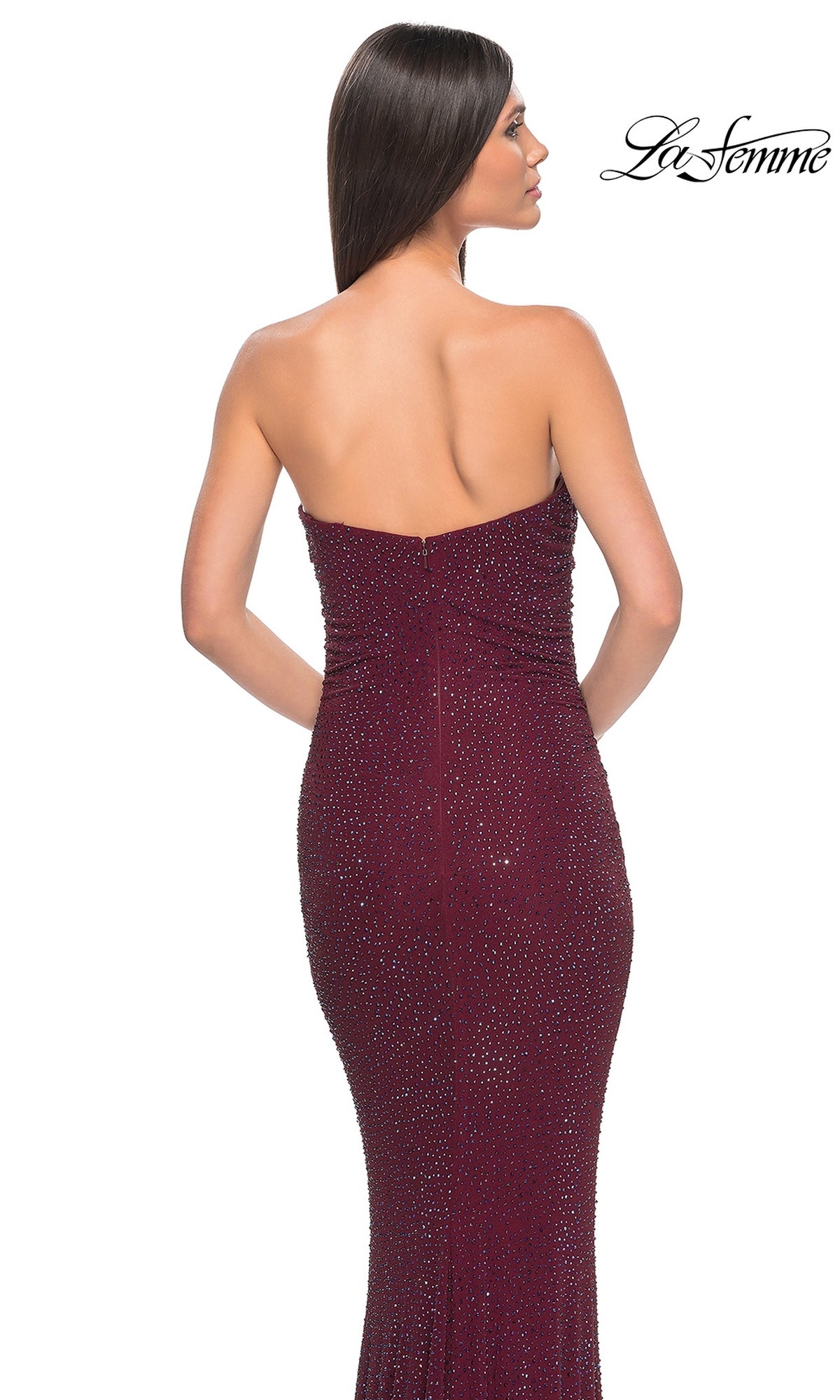 A woman faces away, wearing the La Femme Strapless Long Tube Prom Dress 32141—a fitted, floor-length maroon gown with sparkling accents. The